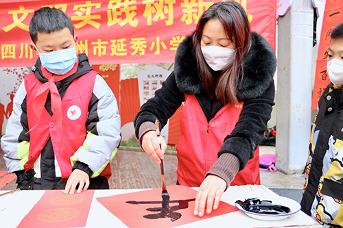 彭州市延秀小学党委进社区开展“志愿服务送关爱 文明实践树新风”写春联、剪纸送祝福活动