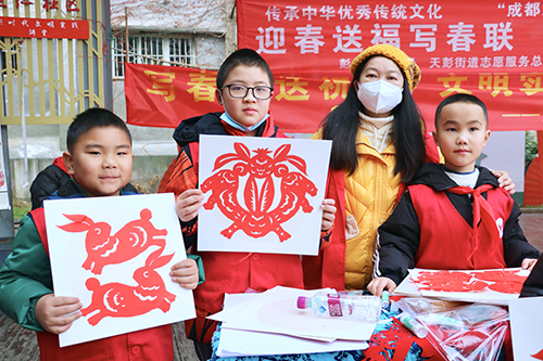 彭州市延秀小学党委进社区开展“志愿服务送关爱 文明实践树新风”写春联、剪纸送祝福活动
